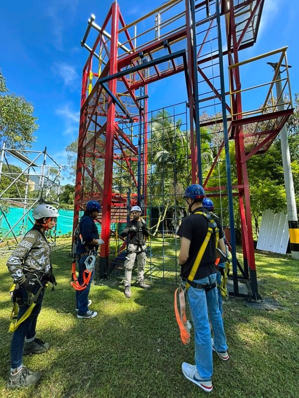 Grupo de trabajadores con arnés recibiendo reentrenamiento junto a la torre