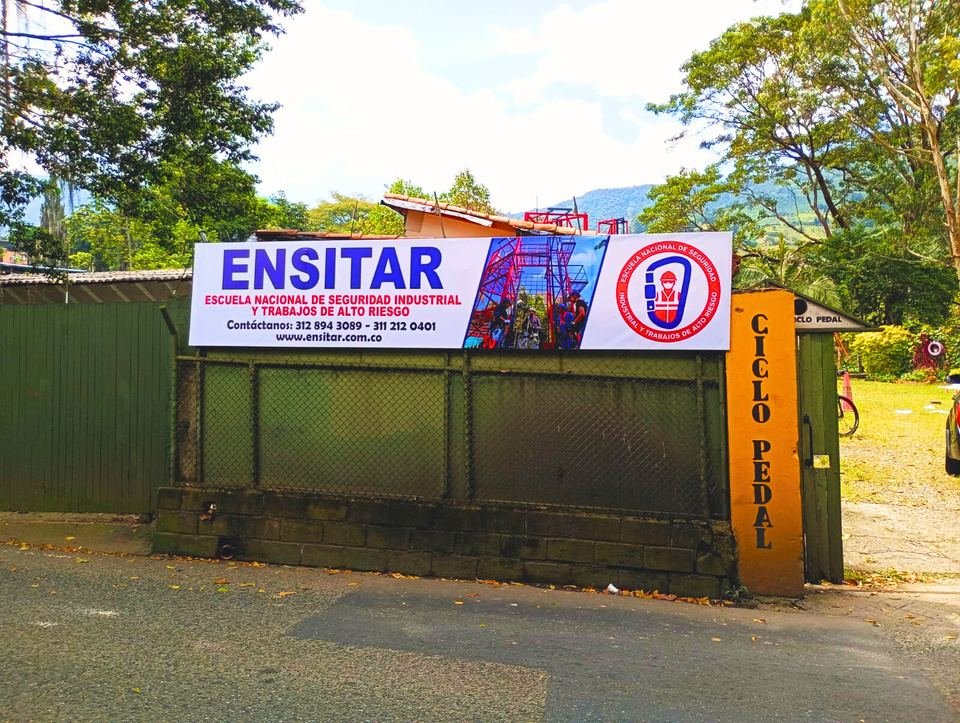 Entrada de ENSITAR: portón verde con la valla de la escuela sobre la vía antigua a San Antonio de Prado